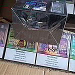 A damaged box of vaping products labeled "15000 PUFFS," with other intact boxes visible in the background.