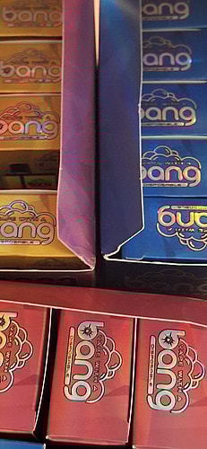 Boxes of disposable vape products with "bang" branding in various colors, including yellow, blue, and red.