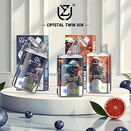 Three uzy Crystal Twin 50k vaping devices showcasing double flavors with unique designs, displayed on a sleek white pedestal surrounded by decorative elements like blueberries and a grapefruit slice.