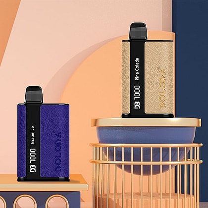 Two box-shaped vape devices labeled "DOLODA D3 1000" with flavors "Grape Ice" and "Pina Colada" are displayed on a geometric arrangement of pastel-colored blocks and cylinders.