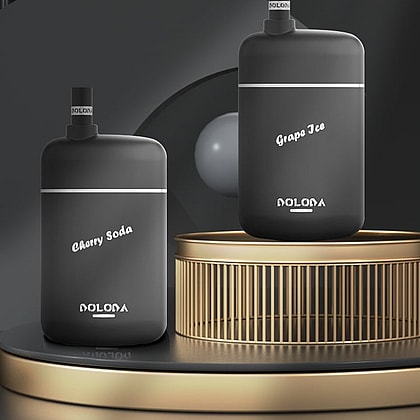 Två svarta vape-enheter märkta "Cherry Soda" och "Grape Ice" visas på en metallisk yta med en minimalistisk mörk bakgrund.