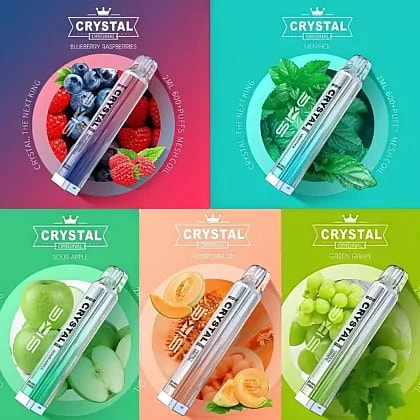 Five different flavors of Crystal vape pens are displayed, including Blueberry Raspberries, Menthol, Sour Apple, Honey Melon, and Green Grape. Each flavor is represented with corresponding fruit images behind the vape pen.