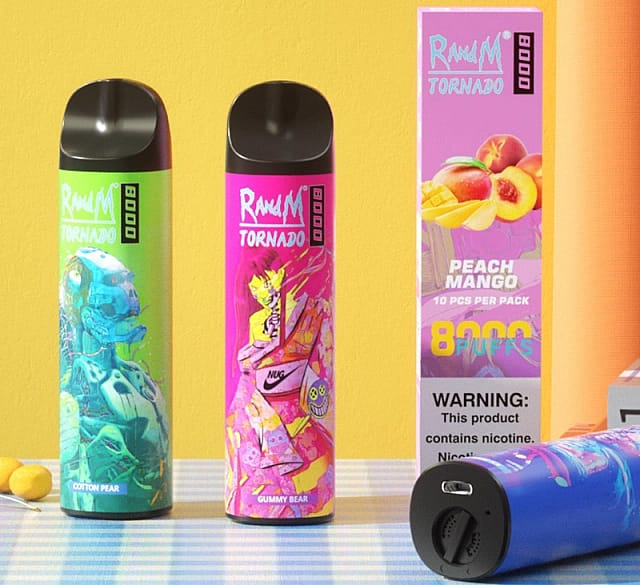 Due dispositivi da svapo colorati etichettati "RandM Tornado 8000", con i gusti "Cotton Pear" e "Gummy Bear", accanto alla confezione del gusto "Peach Mango", con un'avvertenza sul contenuto di nicotina.