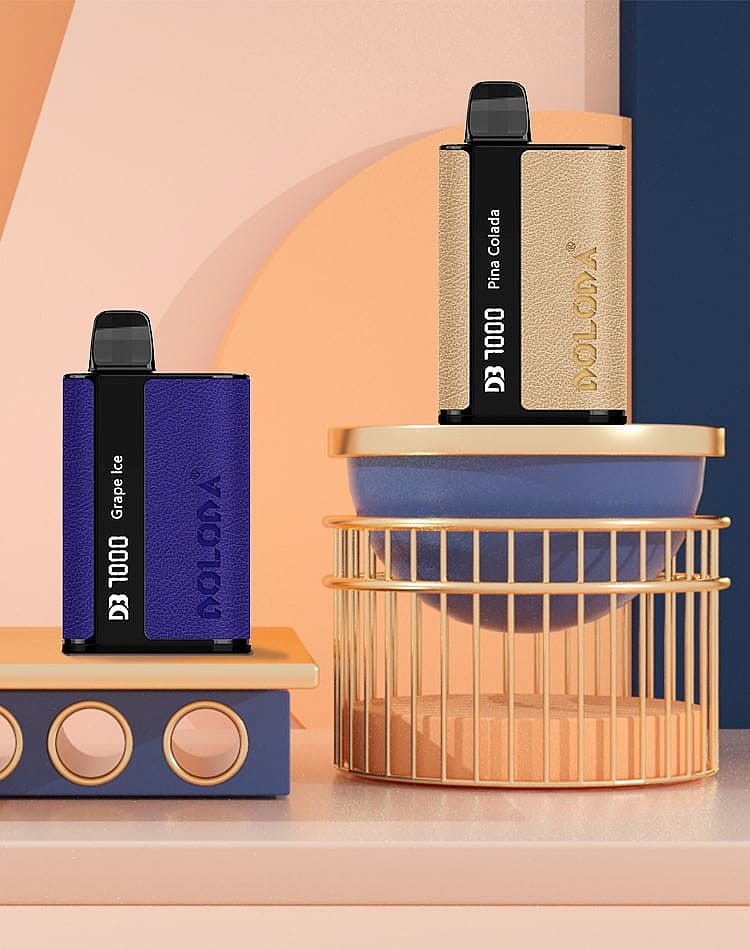 Two box-shaped vape devices labeled "DOLODA D3 1000" with flavors "Grape Ice" and "Pina Colada" are displayed on a geometric arrangement of pastel-colored blocks and cylinders.