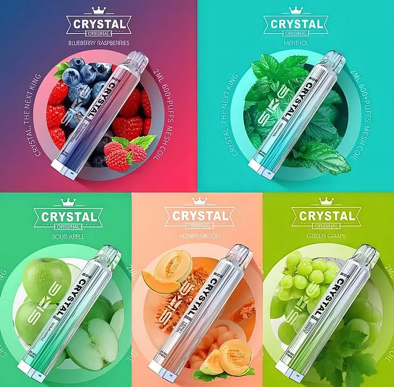 Sono esposti cinque diversi gusti di penne da svapo Crystal, tra cui Blueberry Raspberries, Menthol, Sour Apple, Honey Melon e Green Grape. Ogni gusto è rappresentato con immagini di frutta corrispondenti dietro la penna da svapo.