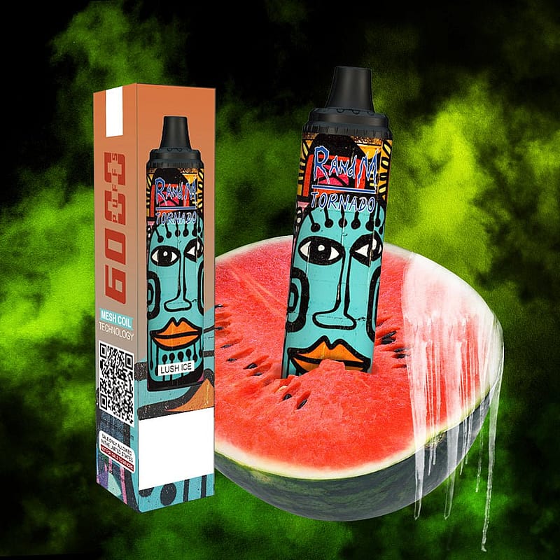 En färgglad vape-enhet med tribal konstdesign, stående upprätt inuti en skivad vattenmelon, bredvid dess förpackningslåda på en bakgrund av grön rök.
