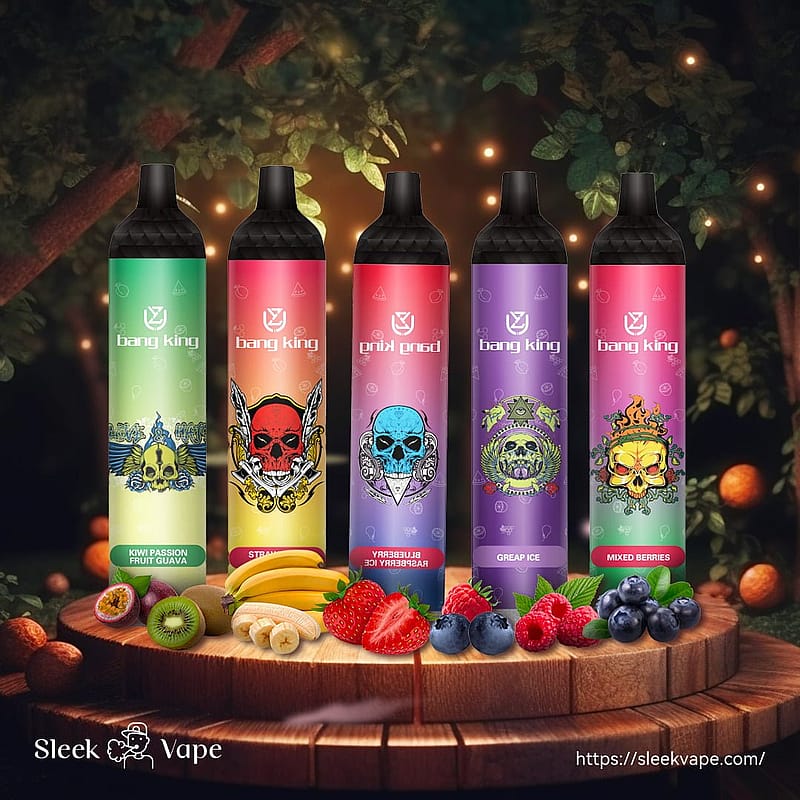 Five colorful vape pens with skull designs, labeled "bang king," are displayed on a wooden platform surrounded by assorted fruits, including kiwi, banana, strawberries, blueberries, and raspberries.