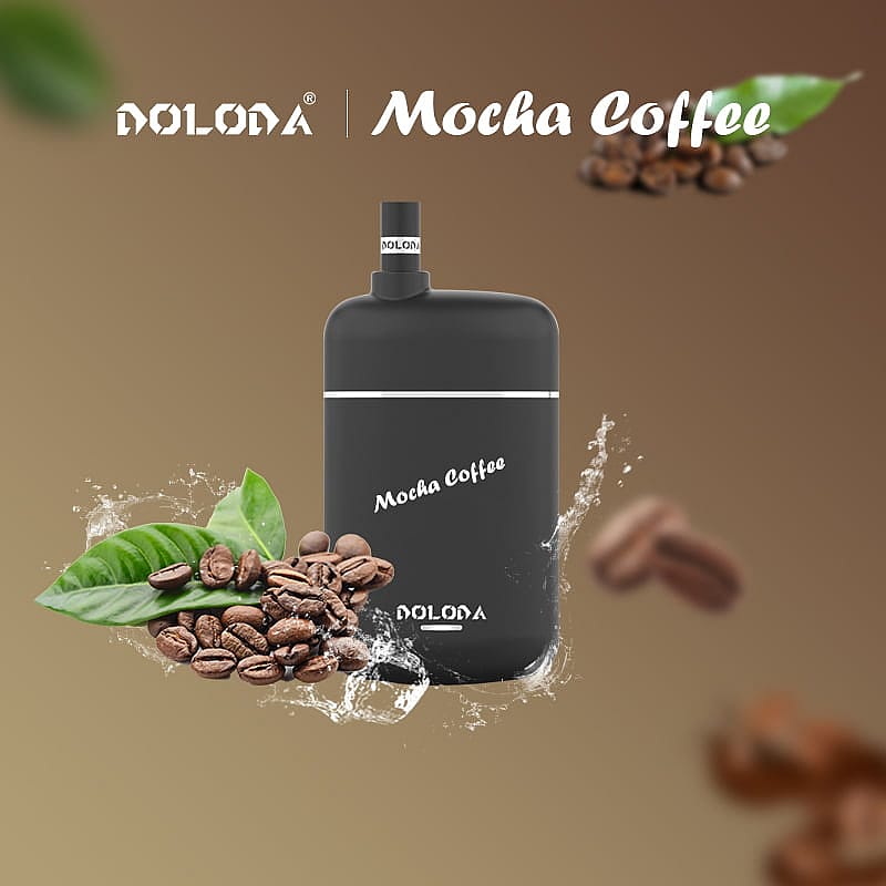 Vape jetable au goût de café moka avec des grains de café et des feuilles sur fond marron.