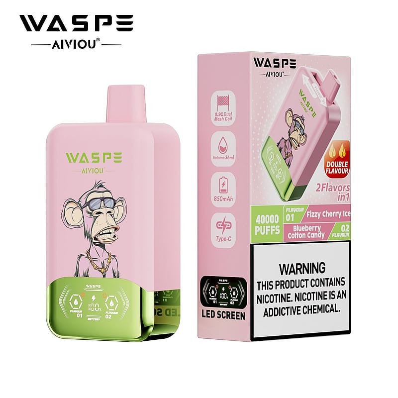 A pink vaping device with a cartoonish monkey design on the front, featuring a green bottom half and an LED screen. The packaging displays information about its dual flavors, "Fizzy Cherry Ice" and "Blueberry Cotton Candy," along with a warning about nicotine.