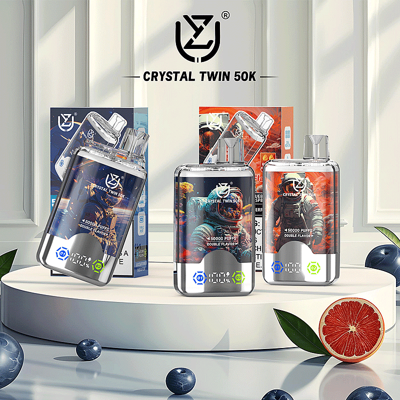 Three uzy Crystal Twin 50k vaping devices showcasing double flavors with unique designs, displayed on a sleek white pedestal surrounded by decorative elements like blueberries and a grapefruit slice.