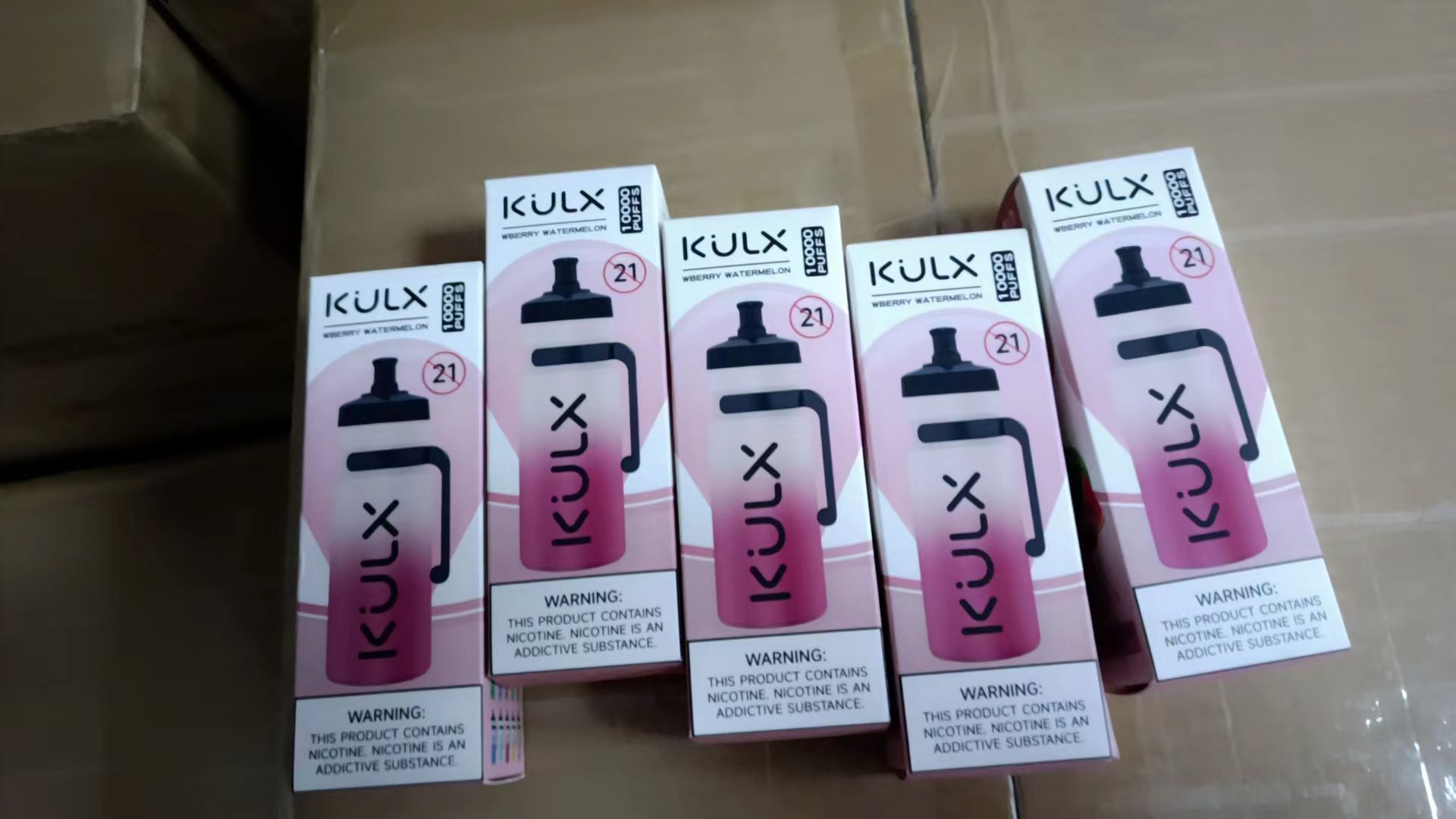 Five boxes of KULX branded disposable vapes labeled "Wberry Watermelon" with "10000 puffs" and nicotine warnings displayed.