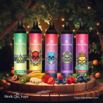 Cinq stylos à vape colorés avec des motifs de crâne, étiquetés "bang king", sont exposés sur une plate-forme en bois entourée de fruits assortis, dont des kiwis, des bananes, des fraises, des myrtilles et des framboises.