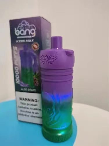 A purple and green disposable vape device labeled "bang" next to its box, featuring the flavor "Blue Grape" and a nicotine warning label.