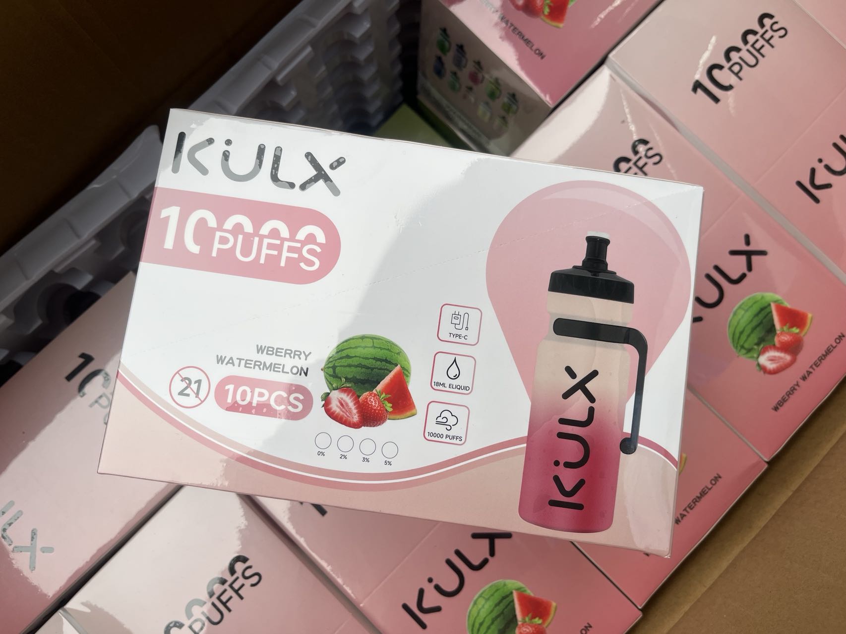 A box of KULX disposable vapes labeled "10,000 PUFFS" in "Wberry Watermelon" flavor, with images of a watermelon and strawberries. The box also shows that it contains 10 pieces, has a Type-C charging port, and 18ml of e-liquid.