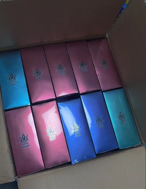 Boxes of Bang Beach products in assorted colors arranged inside an open cardboard box.