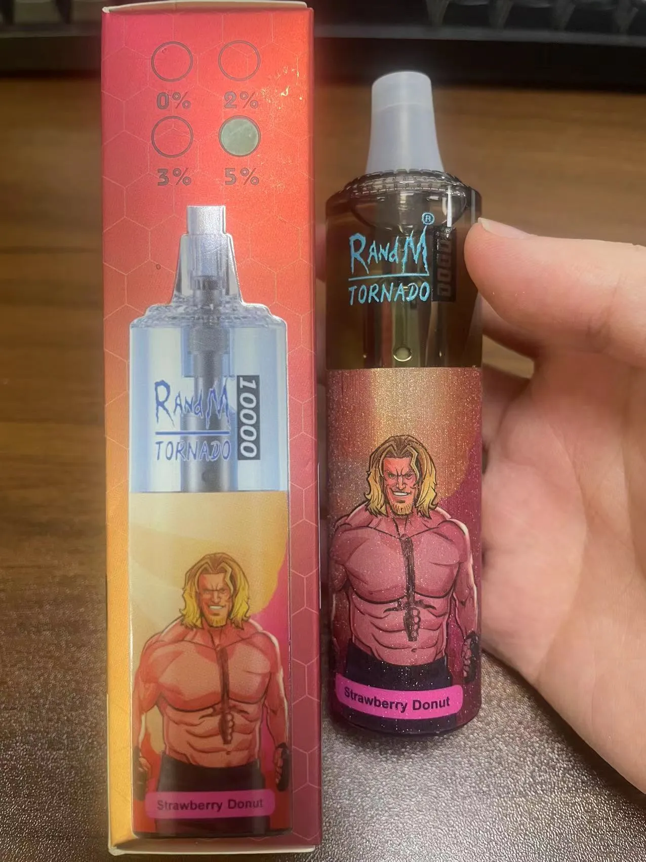 A RandM Tornado disposable vape with a "Strawberry Donut" flavor label and an illustration of a muscular blonde man on the packaging.