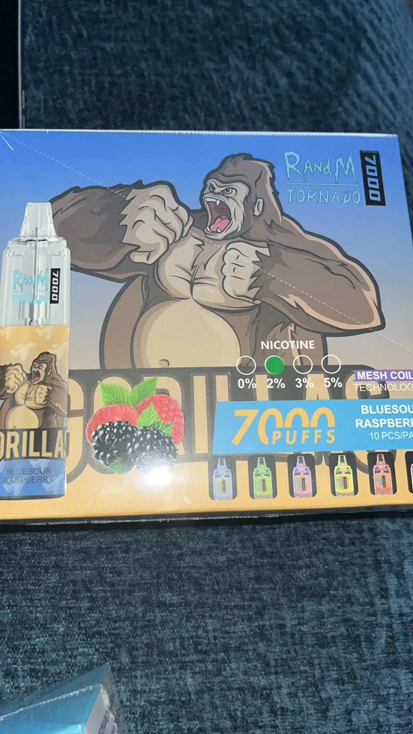 A box of RandM Tornado 7000 puffs disposable vape featuring a gorilla illustration and labeled "Blue Sour Raspberry" flavor with nicotine options from 0% to 5%.