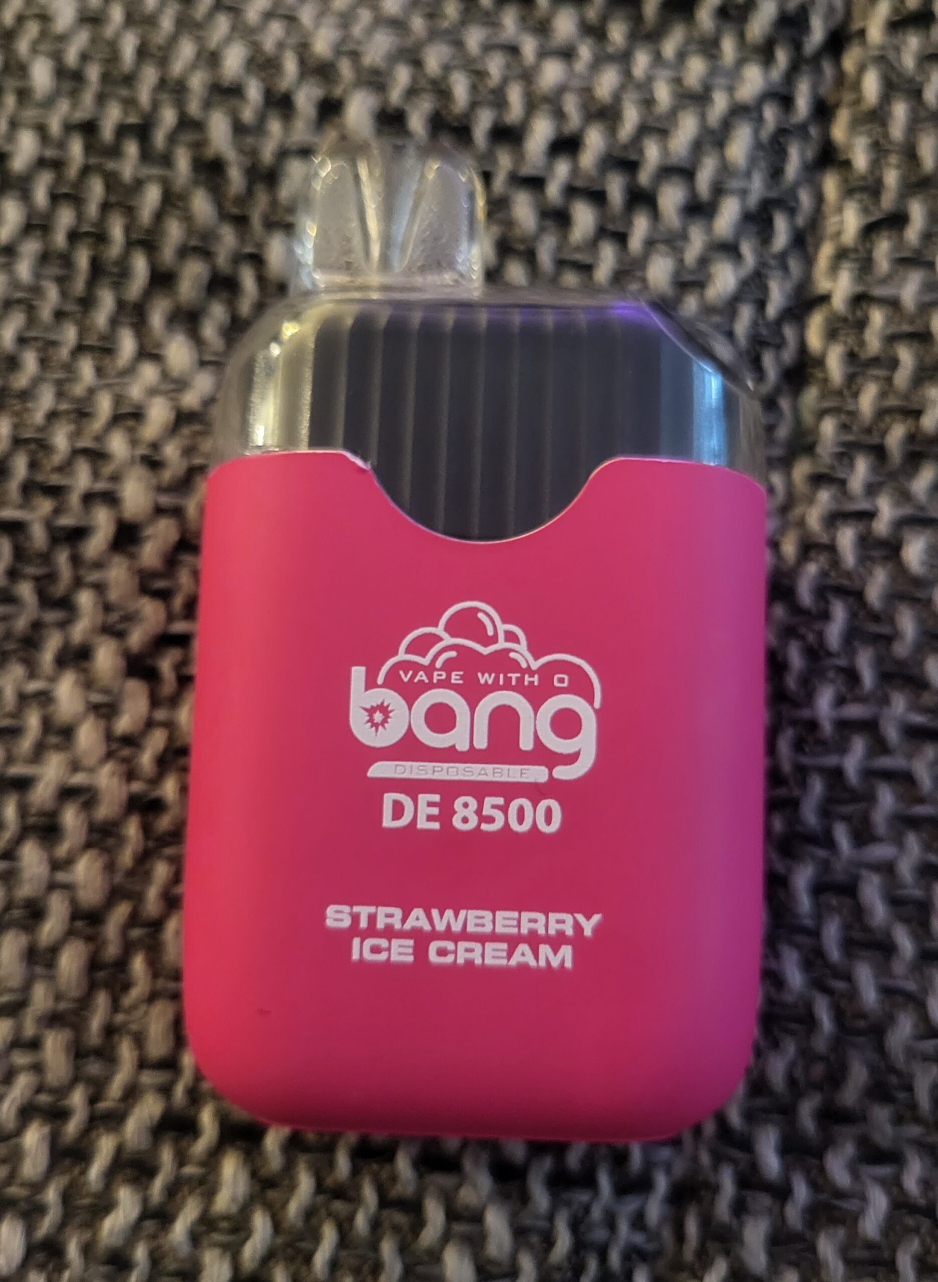 A pink vape device labeled "Bang DE 8500" with the flavor "Strawberry Ice Cream" on a textured background.