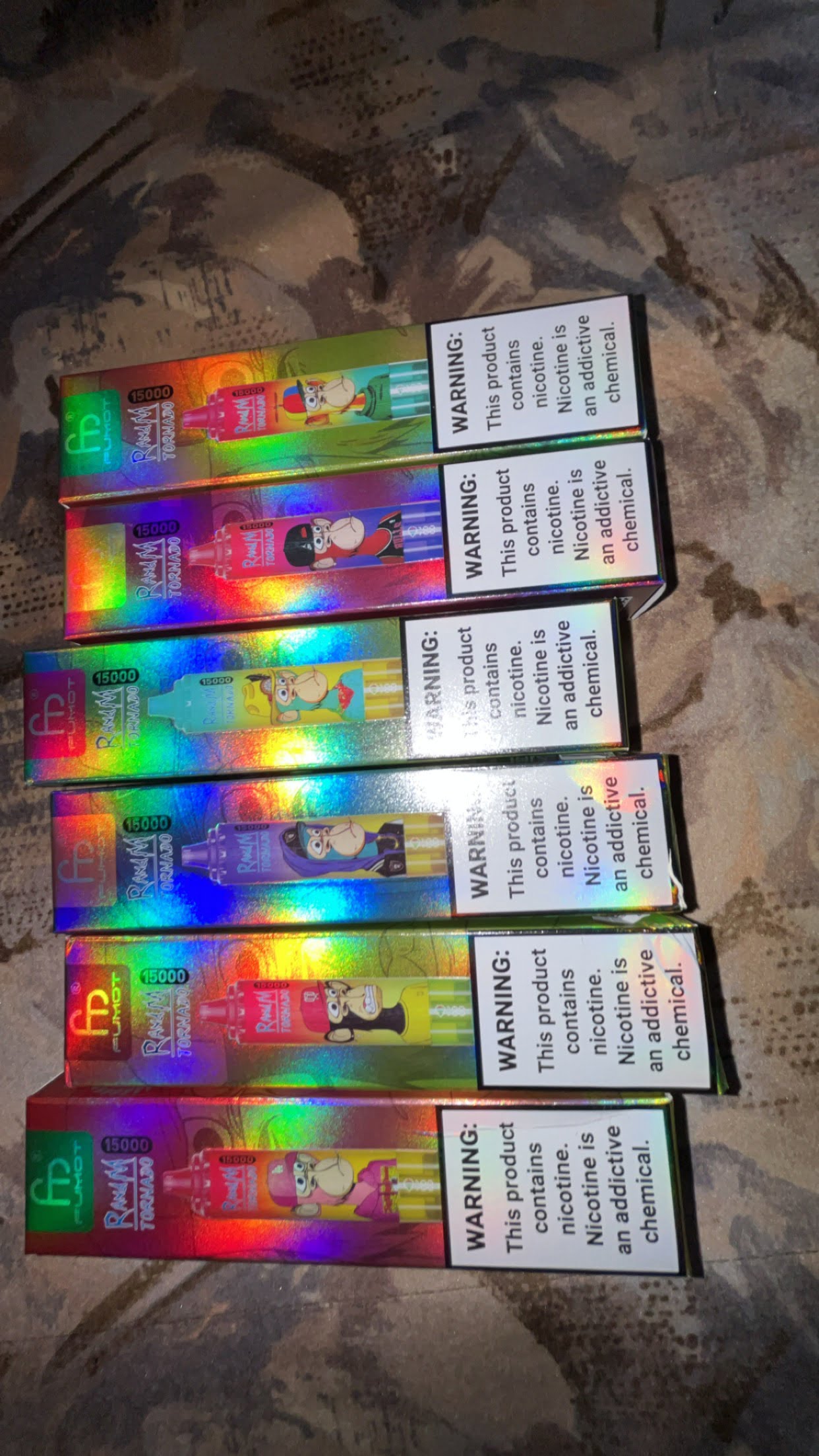 Boxes of vaping products with colorful packaging and nicotine warning labels