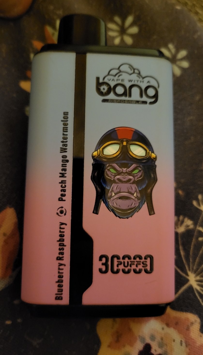 A disposable vape device with the brand name "Bang" featuring a gorilla wearing goggles and a helmet, labeled with 3000 puffs and the flavors Blueberry Raspberry and Peach Mango Watermelon.