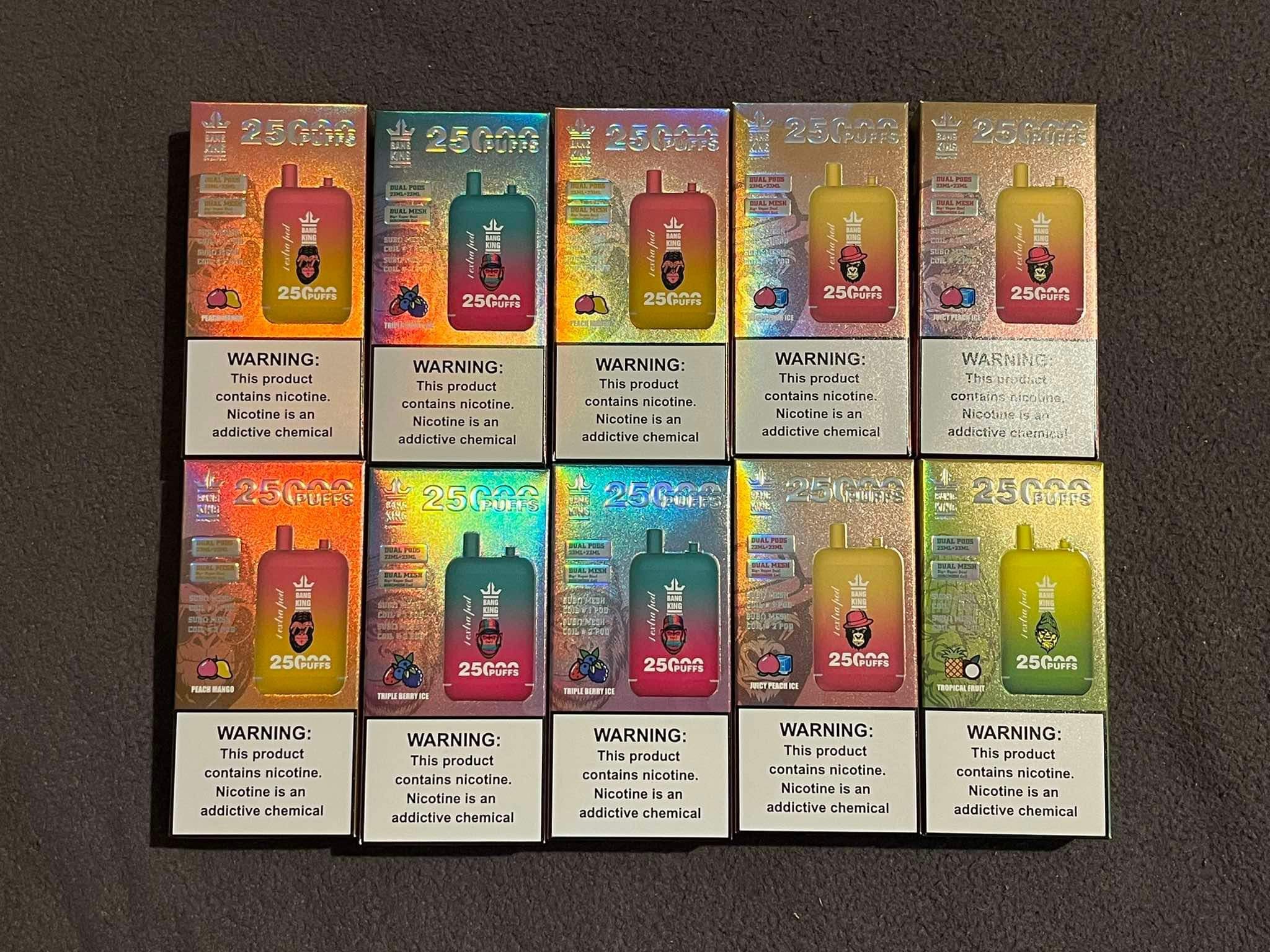 Boxes of vaping products with a warning label stating "This product contains nicotine. Nicotine is an addictive chemical." The boxes have colorful designs and labels indicating 25,000 puffs.